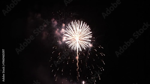 A vibrant burst of colorful pyrotechnics illuminates the dark night sky during a festive July 4th Independence Day celebration