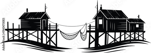 Silhouette fishing huts on stilts with nets in between, calm ocean water with waves