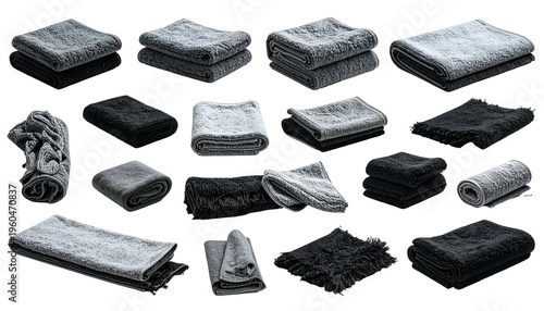 Assortment of folded and rolled soft grey/black textile items on black background