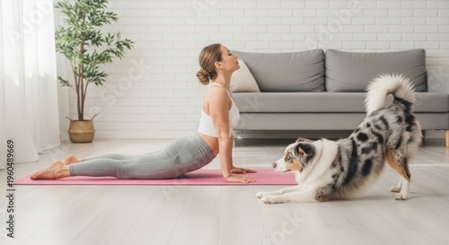 Woman in yoga pose on mat, playful dog mimicking stretch on floor