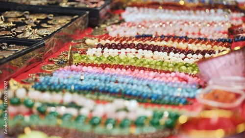 Photography Colorful Indian beaded jewelry and golden pendants for sale at a street market i