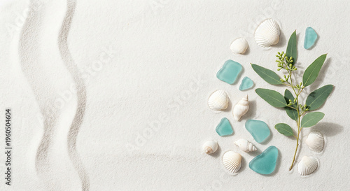 Smooth sea glass and eucalyptus leaves on white rippled sand perfect for peaceful ocean wellness concept and natural summer beauty presentation