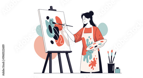 Creative female artist wearing an apron painting on a canvas with a palette and brushes in her studio.