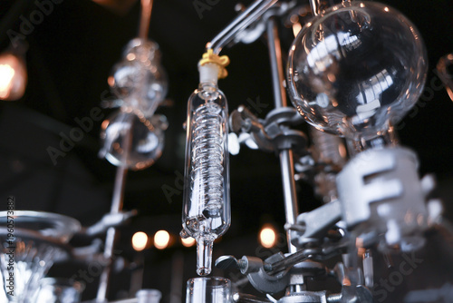Intricate glass chemistry laboratory apparatus equipment featuring distillation condenser flask test tube setup displaying fascinating scientific experiment preparation
