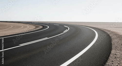 Desert highway curving through barren landscape under a clear sky