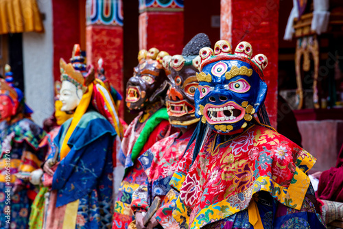 Buddhist monks in vibrant masks and ornate robes perform traditional Cham dance in Ladakh India showcasing spiritual ritual culture and Himalayan heritage.