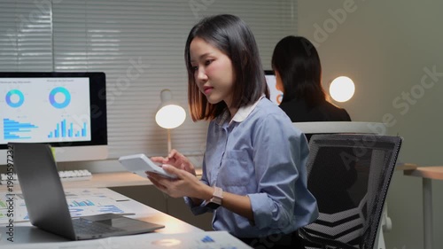 Asian businesswoman working overtime with calculator