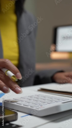 Businesswoman calculating finances and taking notes