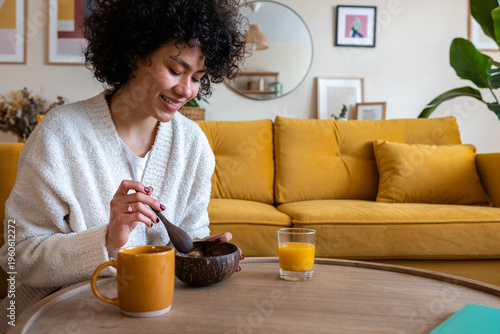 Woman enjoying healthy breakfast at home on sofa