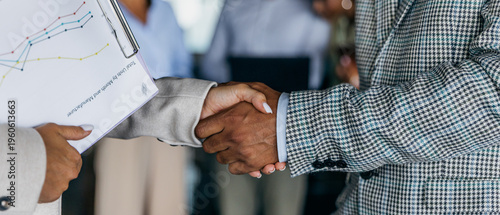 Business colleagues finalize deal with firm handshakes and smiles