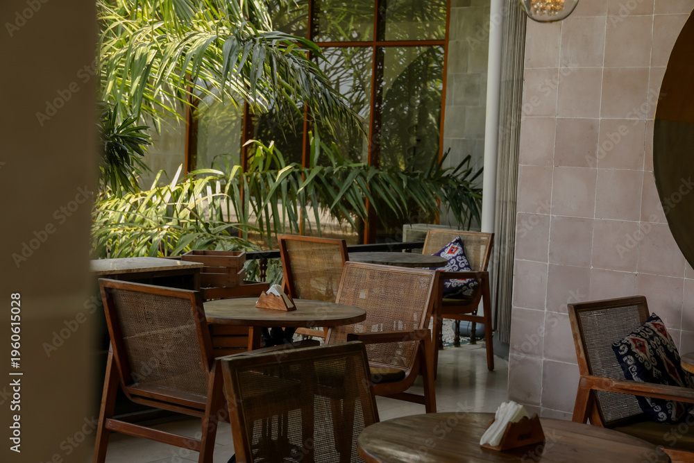 Fototapeta premium Seating area with wooden chairs and plants in a cafe
