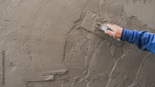Obraz na płótnie Hand plasterer plastering cement wall background, hand worker brush rough concre