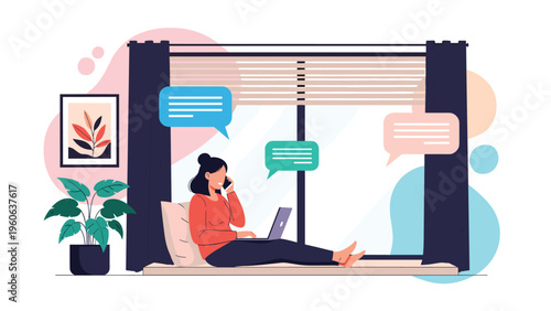 Focused young woman working remotely as a freelancer while sitting by the window and talking on her smartphone with a laptop.