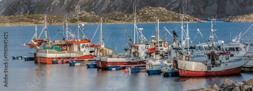red fishing boats moored  in harbor in norwegian village on Mageroya island, ...