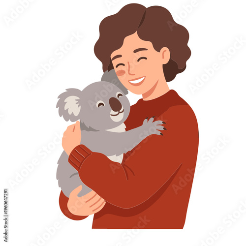 A smiling woman holding a koala bear in her arms indoors
