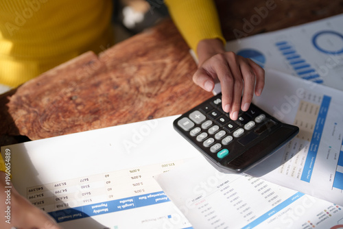 Tableau sur toile Hands using a calculator to process financial data and accounting reports on a w