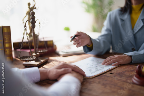 Fotografía Lawyer discussing legal advice with a client, pointing to important sections of