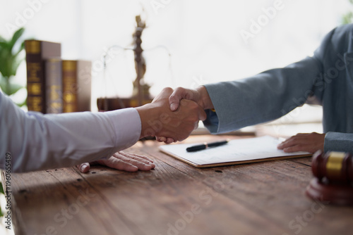 Foto Legal professionals finalizing a business agreement with a handshake, symbolizin