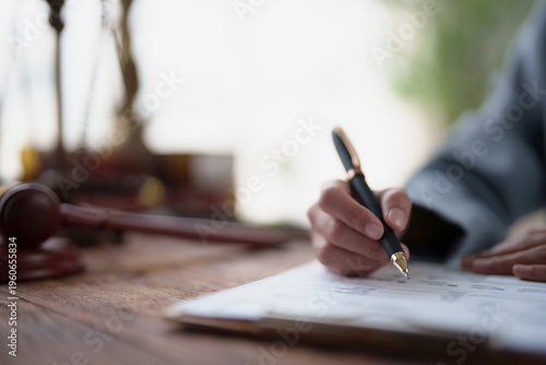 Cuadro en lienzo Lawyer hand writing on an important legal document or contract, with a blur of a