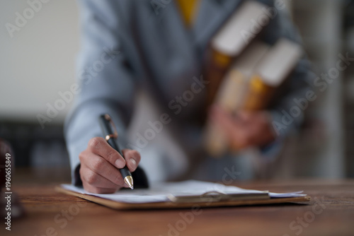 Bild auf Leinwand Business hand holding a pen and writing signature on a contract document placed