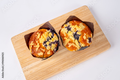 Homemade delicious freshly baked blueberry muffins with crumble topping on wooden board and on top view.