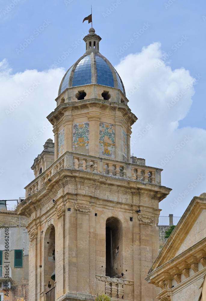 Fototapeta premium Ragusa Ibla baroque church bell tower with ceramic dome. Historic bell tower architecture featuring a blue ceramic dome under a summer sky in Sicily