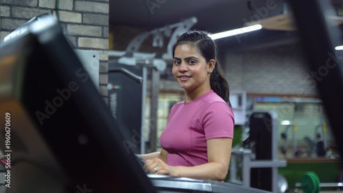Indian Woman Using Treadmill During Cardio Workout in Modern Gym