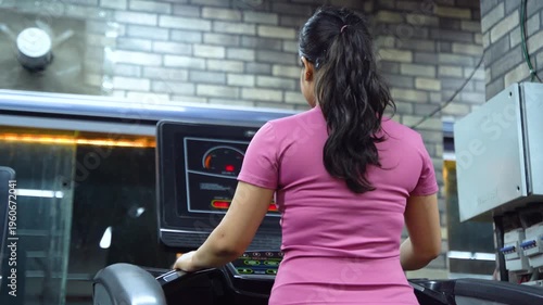 Indian Woman Using Treadmill During Cardio Workout in Modern Gym