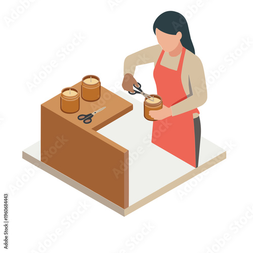 Woman in apron cuts object on table with scissors in workshop