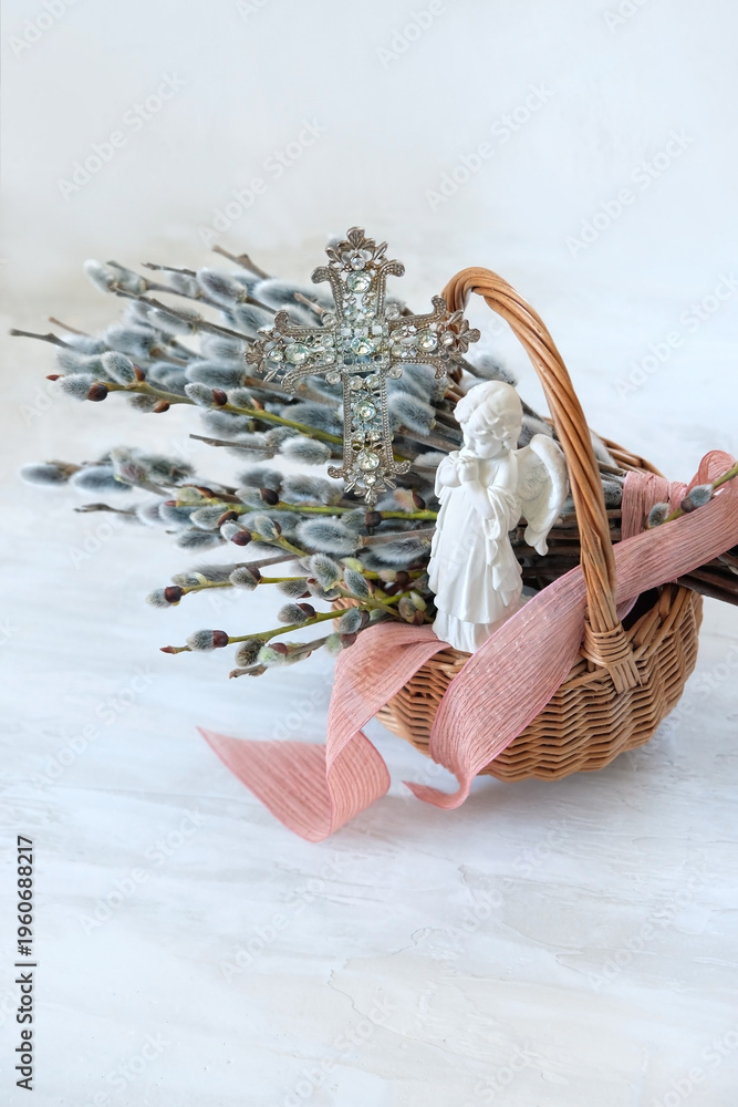 Naklejka premium Palm Sunday background. wicker basket with pussy willow branches, christianity cross, angel figurine on table. symbol of Easter, Palm Sunday holidays. prayer, faith, orthodox Church, religion concept