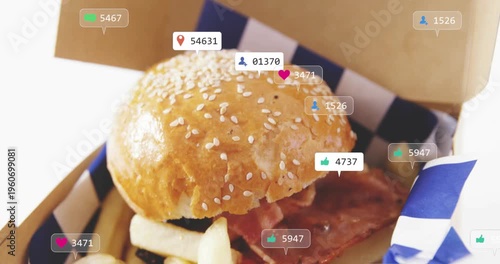 sesame-seed burger and fries sitting in to-go box while social tags appearing, multiplying for ads