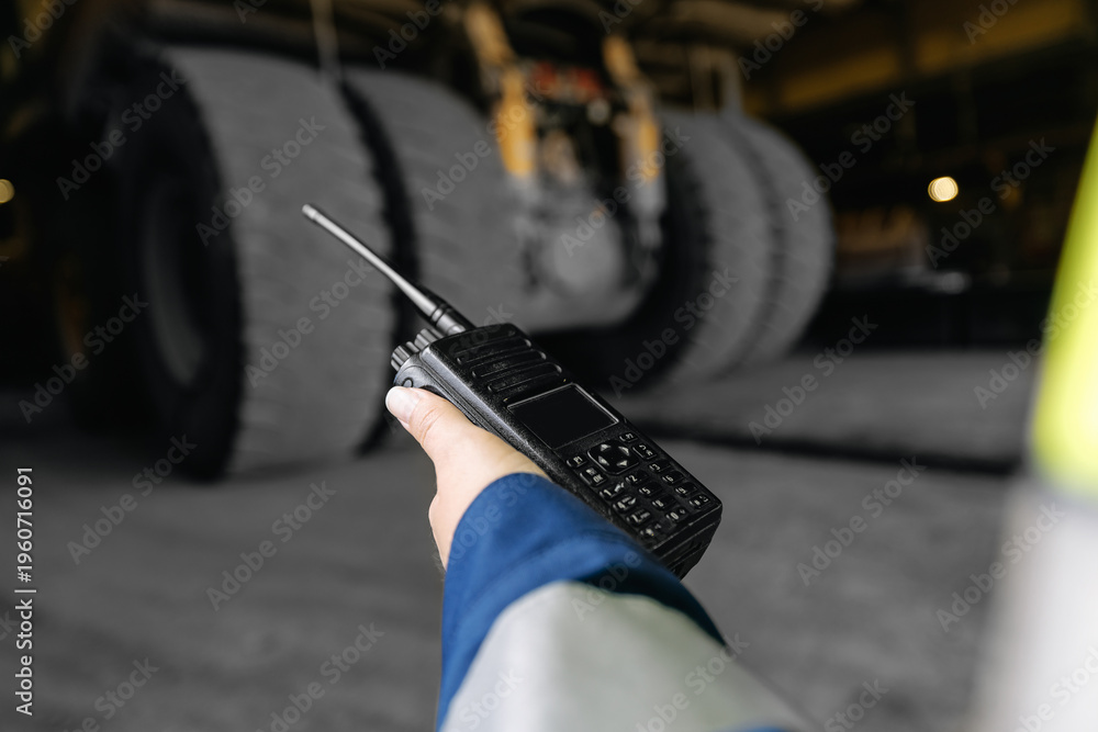 Αυτοκόλλητο Worker using radio communicator near heavy truck wheels in depot, RC mining