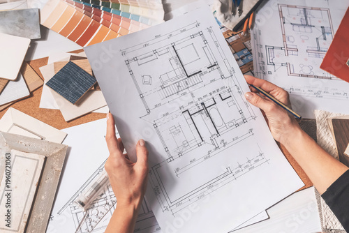 architect Eco retrofit planning with blueprints, material swatches and finish samples, sustainable renovation budget and healthy material selection concept for honest architectural design.