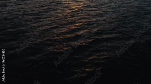 Dark ocean waves reflecting a golden sunset