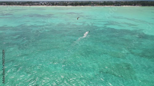 Kitesurfer gliding on turquoise ocean water