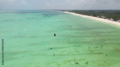 Kitesurfers riding on turquoise water at paje beach, zanzibar
