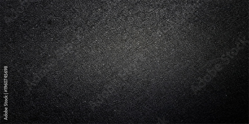 A dark, rough surface of black leather and bitumen creates a textured asphalt pattern with grey stone details, perfect for a macro material backdrop or wallpaper design