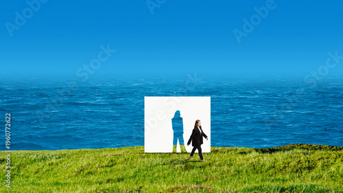 Fotografie Businesswoman walking past human silhouette paper cutout on grass near ocean