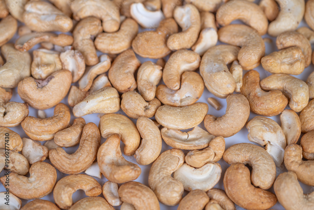 Fototapeta premium Golden brown roasted cashew display. Studiolit closeup of roasted crunchy cashews. Detailed view of crispy roasted cashews highlighting craftsmanship and appealing textures