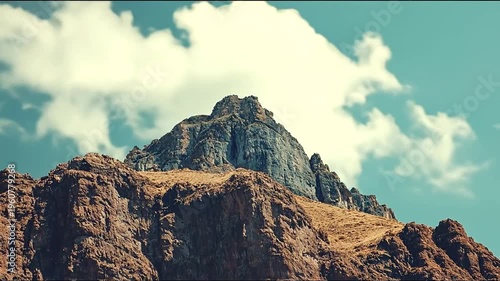 Majestic Mountain Peaks Under a Clear Blue Sky with Fluffy Clouds.