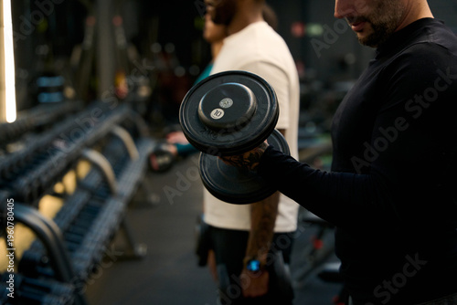 Man training bicep curl with dumbbell at gym