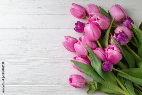 Beautiful pink and purple tulips bouquet on white wooden surface, top view, springtime floral arrangement