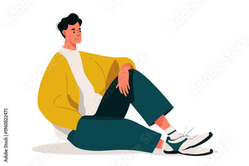 Young caucasian male sitting casually in yellow jacket and sneakers on white background