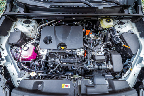 Tableau sur toile Close-up of modern car engine compartment with internal combustion engine and hybrid components for automotive maintenance and technology concepts