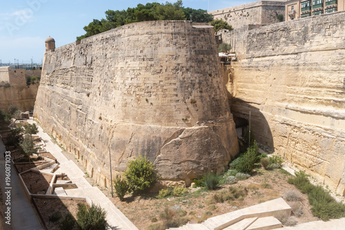 Robust limestone bastion wall and deep moat in Valletta Ditch Garden, MALTA