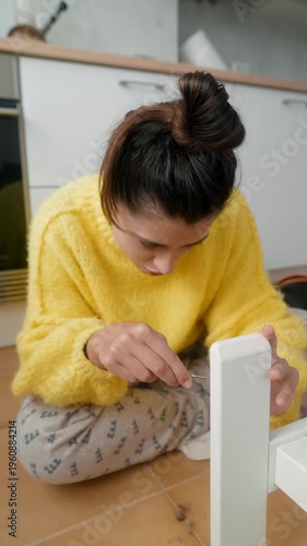 Woman Searches Floor. Young Woman On Tiled Floor Carefully Seeking Tiny Missing Item Near Furniture Leg