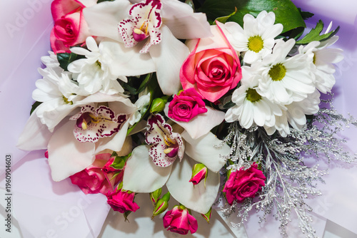 Background for floral arrangement. Beautiful fragrant bouquet with roses, daisies and orchids. Floristry and floral design concept. Floral texture close-up.