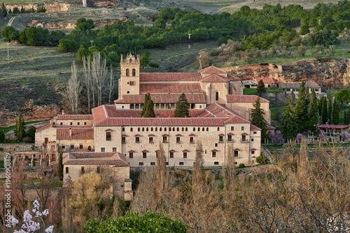 Panoramic view of the Monastery of Santa María del Parral nestled among trees and rolling hills in Segovia, Spain. Historic religious complex featuring traditional architecture 