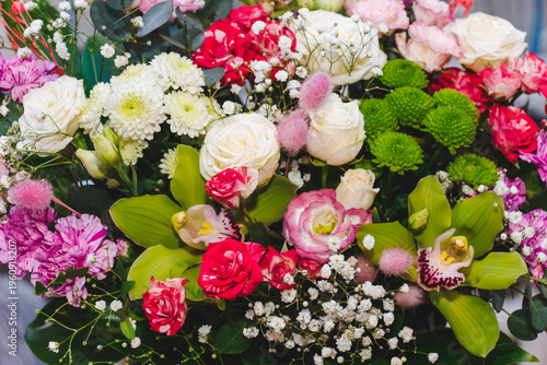 Different types of white, pink roses, and other flowers in floral arrangement. Beautiful fragrant bouquet. Floristry and floral design concept. Floral texture close-up.