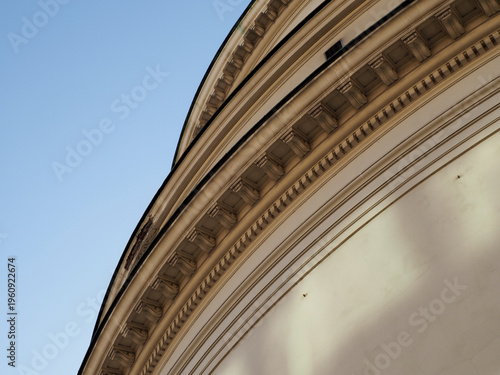 Abstract architectural shot of a curved neoclassical facade with deep shadows